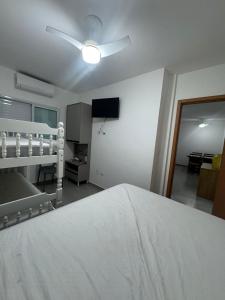 Apartamento vista mar 72 في برايا جراندي: غرفة نوم بها سرير ومروحة سقف