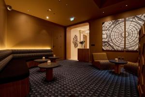 a waiting room with couches and tables and a mural at 6 VH Hotel in Paris
