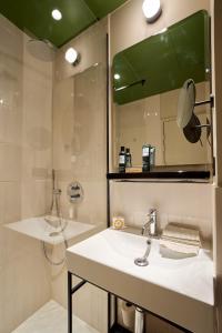 a bathroom with a sink and a mirror and a shower at 6 VH Hotel in Paris