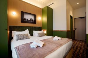 a hotel room with a bed with towels on it at 6 VH Hotel in Paris