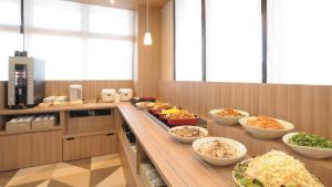 una linea a buffet con ciotole di cibo in cucina di AB Hotel Tahara a Tahara