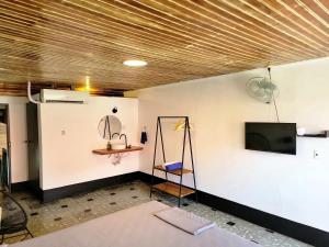 a room with a tv on a wall and a chair at Poco a Poco Junior in León