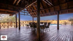 马布拉Zebula Golf and Wildlife Estate - Open Plains Pax 10 - Moi Signature Luxury villa的一个带桌椅的甲板和一个游泳池