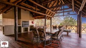 马布拉Zebula Golf and Wildlife Estate - Open Plains Pax 10 - Moi Signature Luxury villa的铺有木地板的用餐室配有桌椅