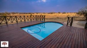 马布拉Zebula Golf and Wildlife Estate - Open Plains Pax 10 - Moi Signature Luxury villa的木制甲板上设有一个小型游泳池