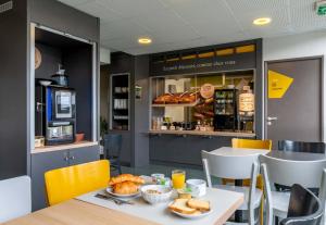 a table with food on it in a restaurant at B&B HOTEL Le Havre Harfleur 1 in Harfleur