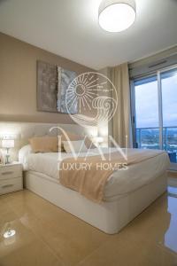 ein Schlafzimmer mit einem großen Bett und einem großen Fenster in der Unterkunft Casa Mediterranea Ivan Luxury Homes 7ªPlta Norte 1ªLinea in Oropesa del Mar