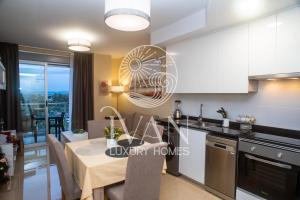 eine Küche und ein Esszimmer mit einem Tisch und einem Ventilator in der Unterkunft Casa Mediterranea Ivan Luxury Homes 7ªPlta Norte 1ªLinea in Oropesa del Mar