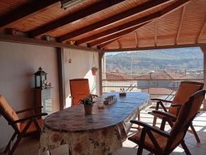 a dining room table with chairs and a large window at The Stoners apartment in Kalabaka