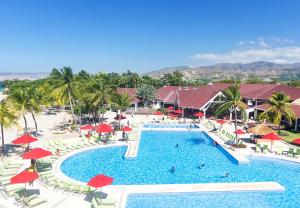 una vista aérea de una piscina del complejo con sillas y sombrillas en Royal Decameron Indigo - All Inclusive, en Montrouis