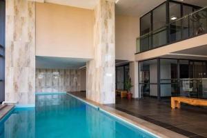 a swimming pool with a wooden bench in a building at 203 Marina Bay Luxury Apartments Suite, Umhlanga in Durban