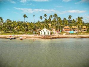 una casa en la orilla de un cuerpo de agua en Design & Conforto Praia aos seus Pés Flats Mauê, en Tamandaré