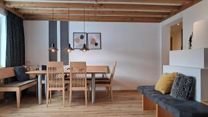 a dining room and living room with a table and chairs at Apart Austria in Nauders