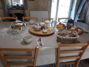 a table with a breakfast of bread and fruit on it at Manoir de Questinguy in Allineuc +23 photos