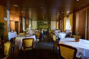 a dining room with tables and chairs with white table cloth at Grand Hotel Bellavista Palace & Golf in Montecatini Terme