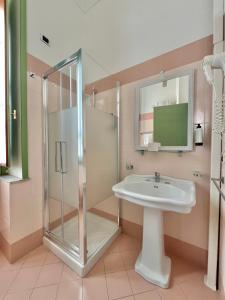 a bathroom with a sink and a shower at Hotel Posta in Syracuse +35 photos