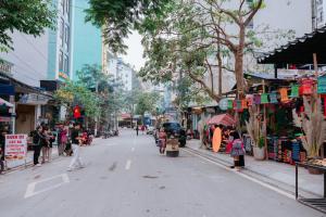a street in a city with people walking and shops at SECRET GARDEN Hostel - WANDERNEST Cat Ba in Cat Ba