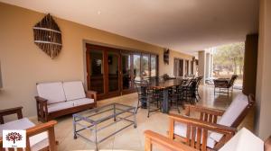 ein Wohnzimmer mit Tisch und Stühlen in der Unterkunft Zebula Golf and Wildlife Estate - Owl's Haven Pax 10 - Moi Signature Luxury villa in Mabula + 43 Fotos