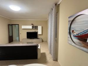 a living room with a couch and a television at Casa Olivella in Santa Flavia