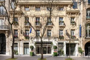 a large building with flower boxes on the windows at Renaissance Paris Nobel Tour Eiffel Hotel in Paris