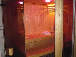 eine Sauna mit Holzwänden und einer Glastür in der Unterkunft B&B V.K. PGmbH in Sankt Vith