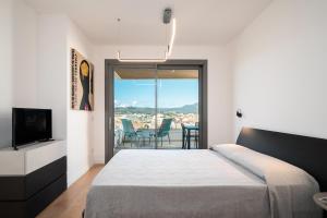 a bedroom with a bed and a flat screen tv at Alfiere Arc Loft by Klodge in Olbia