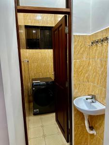 a bathroom with a sink and a washing machine at Casazuri Homestay in Dar es Salaam +38 photos