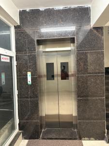 an elevator in a building with black tiles at Hotel Park Varaahi in Tirupati +26 photos