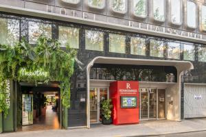 a facade of a building with a red door at Renaissance Paris Republique Hotel & Spa in Paris