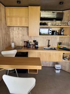 a kitchen with wooden cabinets and a table and chairs at Escapada romántica en El Leon in San Javier