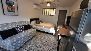 a small living room with a couch and a bed at Studio climatisé Lantanas 4 personnes in Le Lavandou