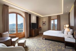 pokój hotelowy z łóżkiem i dużym oknem w obiekcie Renaissance Tuscany Il Ciocco Resort & Spa w mieście Barga