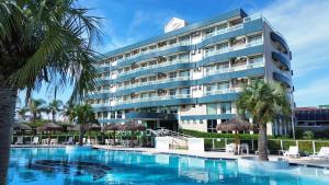 a hotel with a swimming pool in front of a building at Oceania Park Hotel Spa & Convention in Florianópolis