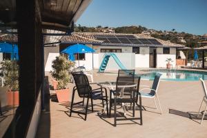 a patio with a table and chairs next to a pool at Colonna Galapagos Garden Hotel in Búzios