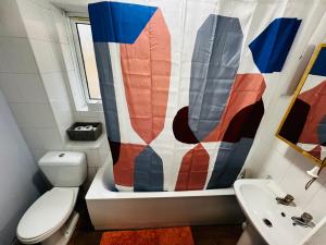 a bathroom with a toilet and a shower curtain at Chic 2BR escape near Luton Airport&Train Stn, Whipsnade zoo, Contractors in Luton
