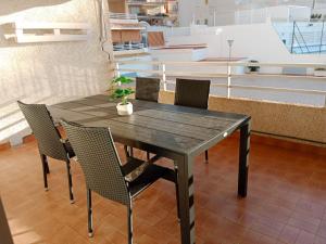 a black table with chairs and a potted plant on it at Los Olivos BB1 in Faro de Cullera