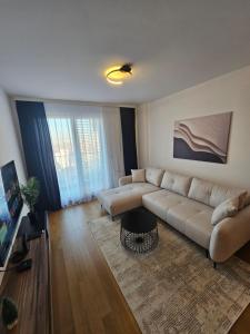 a living room with a couch and a table at Skyline Cozy Suites in Novi Sad +4 photos