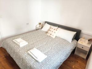une chambre avec un lit avec des draps blancs et des oreillers dans l'établissement Casa Moara - Downtown Duplex House, à Porto