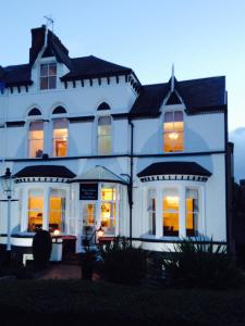 una grande casa bianca con le luci accese di Haversham House - Adults Only a Llandudno