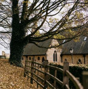 a fence in front of a church with a tree at The Old Palace Lodge in Lincoln