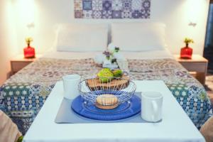 a tray with a bowl of fruit on a bed at Residence Nonna Mariuccia in Mazara del Vallo +118 photos