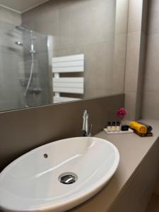 een witte wastafel in een badkamer met een spiegel bij Appartement Belle Mer - Adults Only in Middelkerke +18 foto's