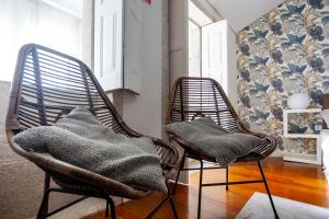 two wicker chairs sitting in a living room at Citybreak-apartments Lapa in Porto