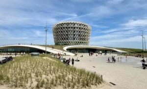 een gebouw op een strand met mensen die eromheen lopen bij Appartement Belle Mer - Adults Only in Middelkerke