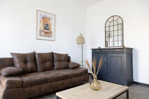 a living room with a brown couch and a table at Maison COSY et CHALEUREUSE au centre ville in Mont-de-Marsan +27 photos