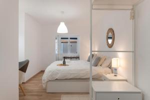 ein weißes Schlafzimmer mit einem Bett und einem Spiegel in der Unterkunft Villa Berkana De Lujo Con Piscina in Playa Honda + 23 Fotos