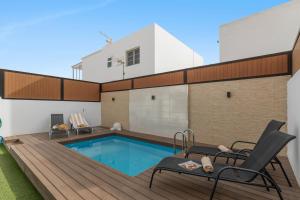 ein Hinterhof mit einem Swimmingpool und einem Haus in der Unterkunft Villa Berkana De Lujo Con Piscina in Playa Honda