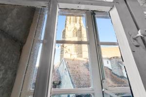 a window with a view of a clock tower at Studio charmant dans la vieille ville de Fribourg in Fribourg