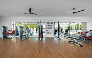 a gym with several tread machines in a room at The Red Room Alanis Residence in Sepang