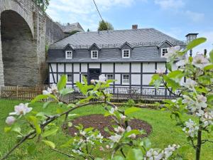 an old white and black house with a bridge at Stachelburg in Monschau
